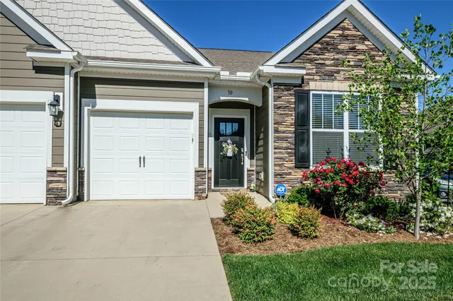 a view of a house with a yard and potted plants