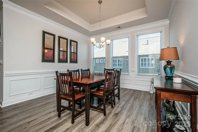 a view of a a dining room with furniture window and wooden floor