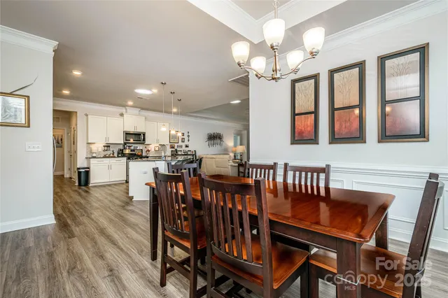 a dining room with furniture a chandelier and wooden floor