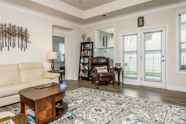 a living room with furniture a flat screen tv and a window