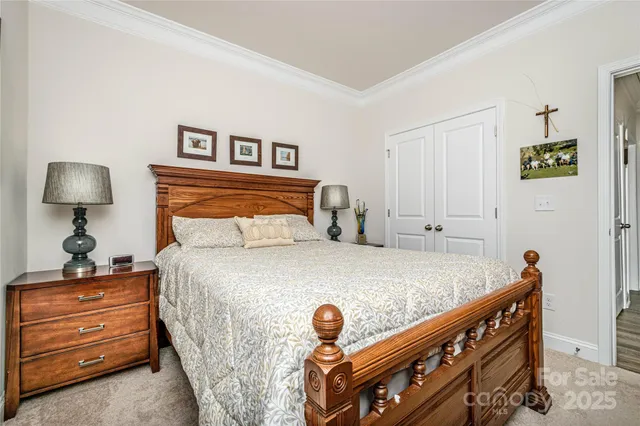 a bedroom with a bed and a lamp on dresser