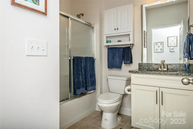 a bathroom with a granite countertop toilet sink and mirror