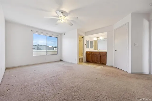 a view of an empty room with a chandelier fan