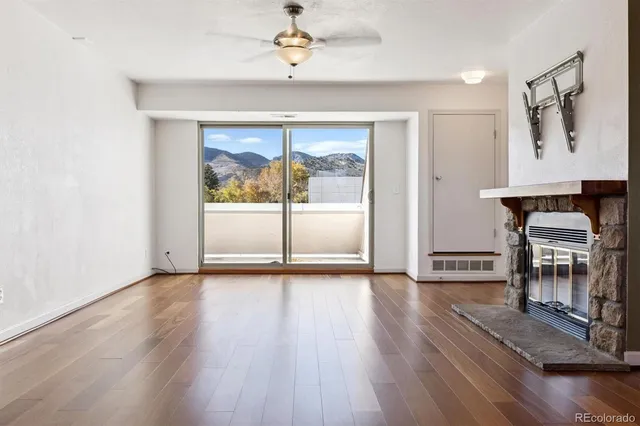 a view of a livingroom with furniture wooden floor a ceiling fan and a window