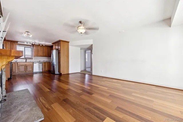 a view of a kitchen with wooden floor and a ceiling fan