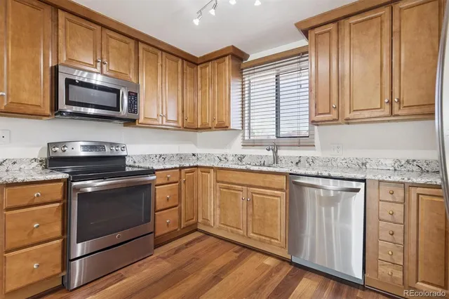 a kitchen with stainless steel appliances granite countertop a stove a sink and a microwave