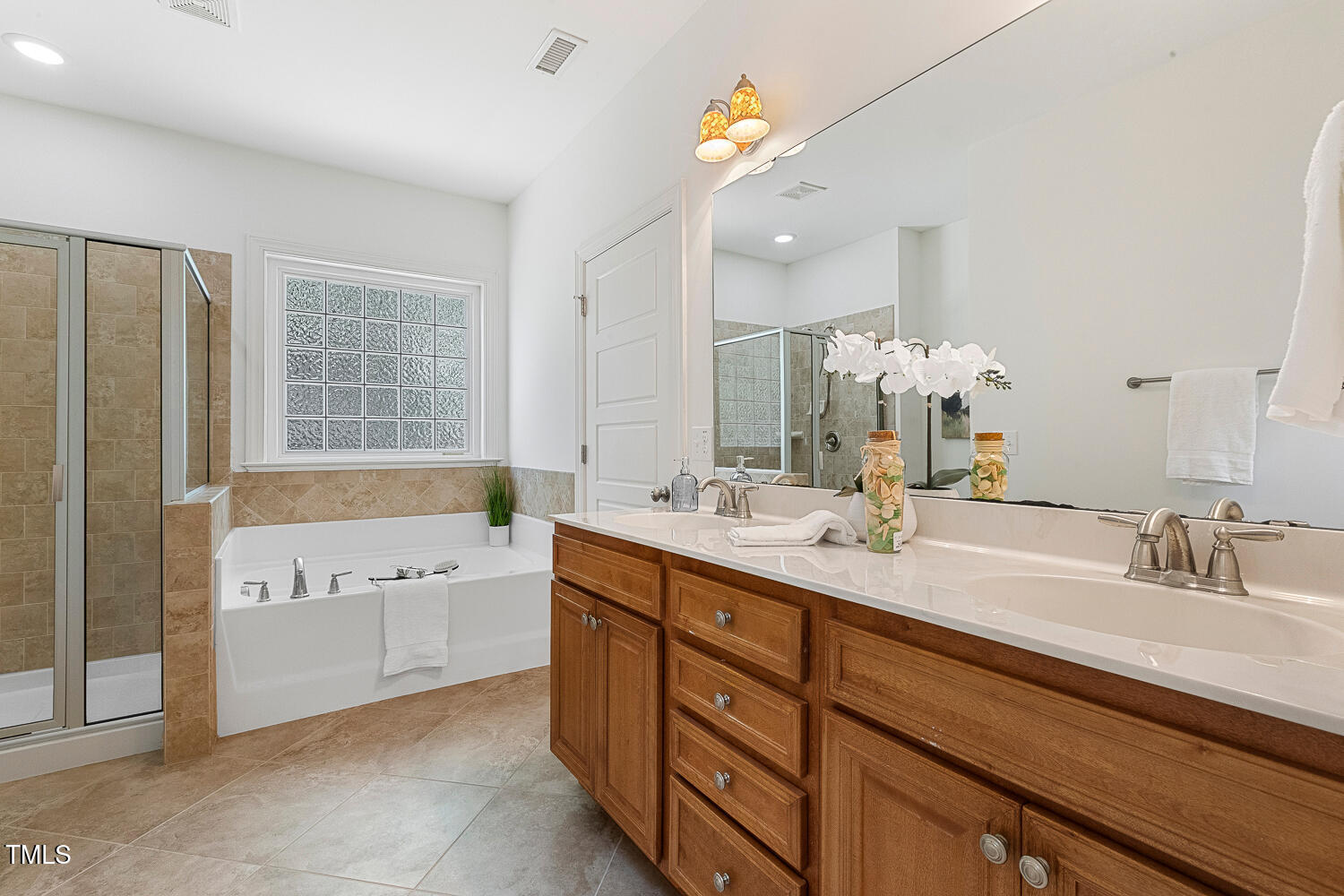 1313 Barnford Mill Road Wake Forest, NC 27587 - Photo 32 of 49 a bathroom with a tub a sink double vanity and a mirror