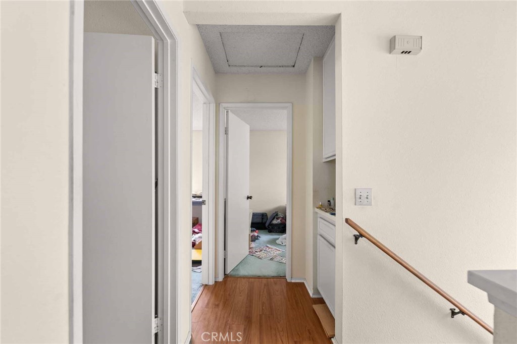 4142 Ocaso Way Oceanside, CA 92056 - Photo 9 of 16 a view of hallway with walk in closet and wooden floor