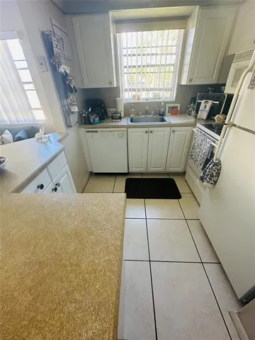 a kitchen with a sink a stove and cabinets