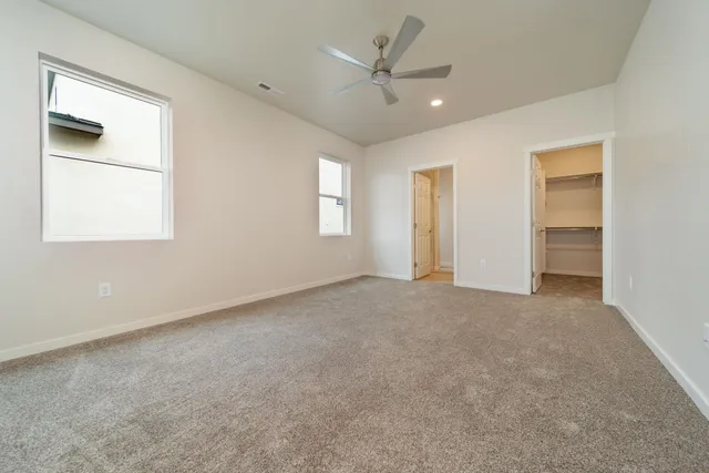 an empty room with a window and a ceiling fan