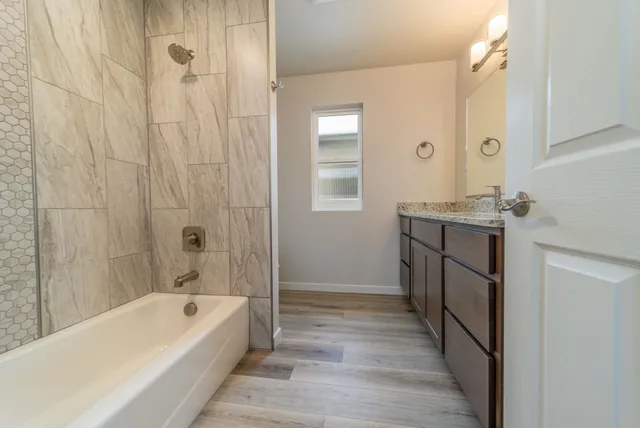 a bathroom with a tub a sink and a mirror