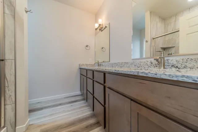 a bathroom with a granite countertop sink and a mirror