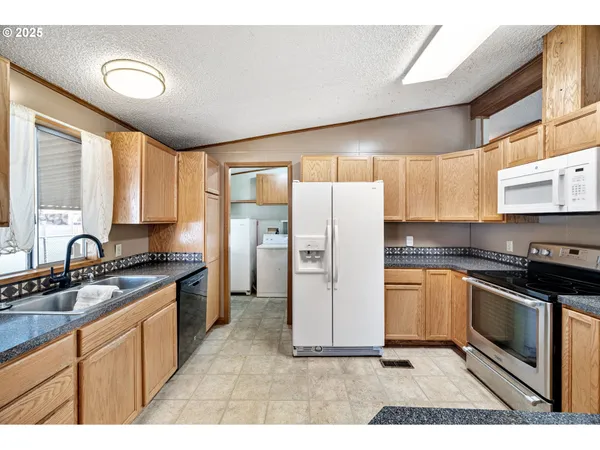 a kitchen with a refrigerator sink and cabinets