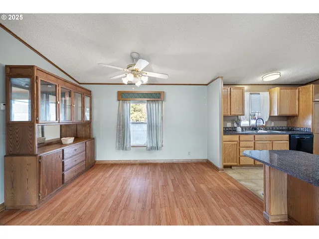 a open kitchen with cabinets wooden floor and stainless steel appliances