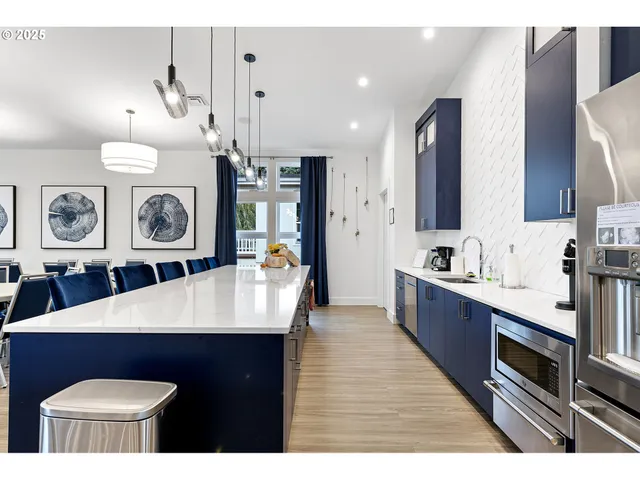 a large kitchen with stainless steel appliances a stove a chimney a sink and a stove