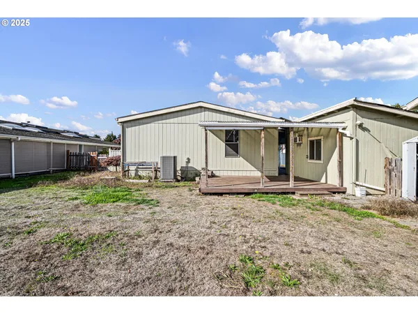 a view of a house with backyard and a tree