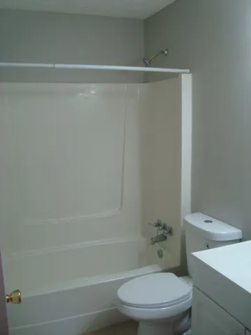 a white toilet sitting next to a bath tub