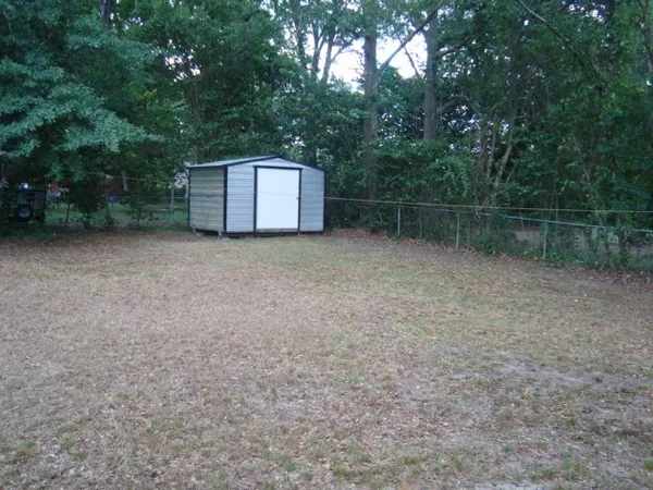 a backyard of a house with lots of green space and trampoline