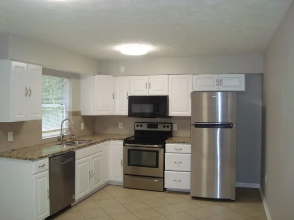 a kitchen with white cabinets and stainless steel appliances
