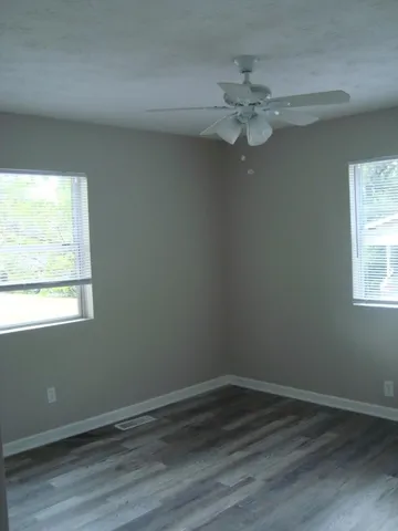 wooden floor in an empty room with a window