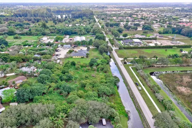 an aerial view of residential houses with outdoor space and trees