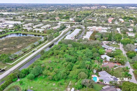 an aerial view of residential houses with outdoor space and trees