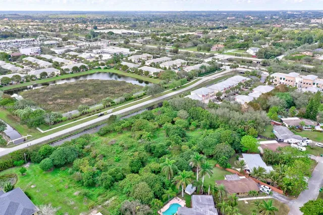 an aerial view of residential houses with outdoor space and trees