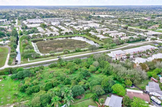 an aerial view of residential houses with outdoor space and trees