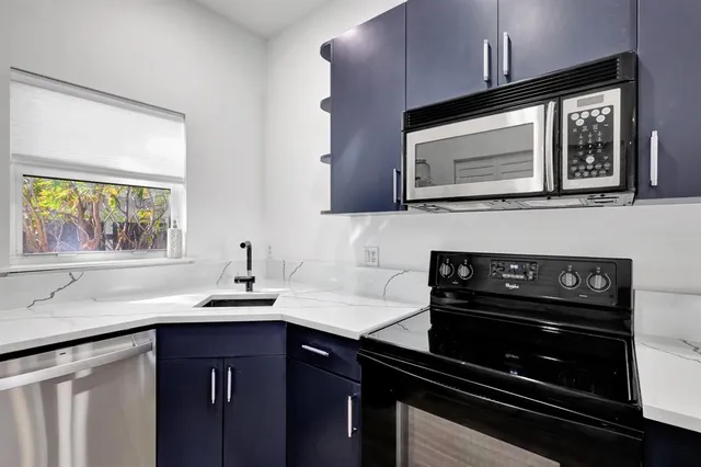 a view of a kitchen with an empty room and wooden floor