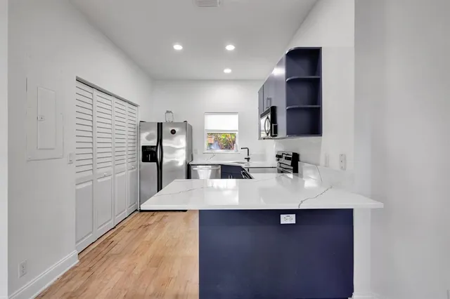a large white kitchen with sink a counter space and appliances