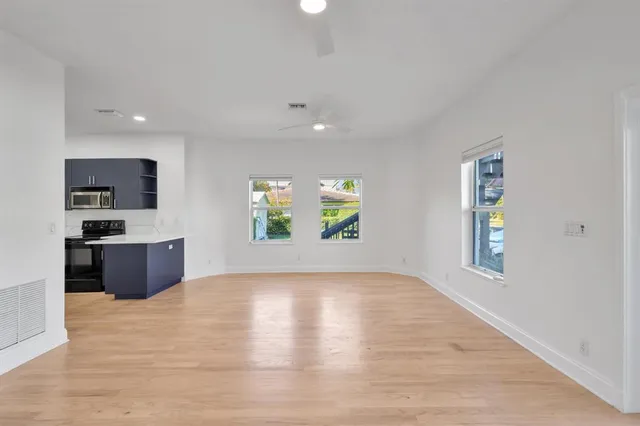 an empty room with window and wooden floor
