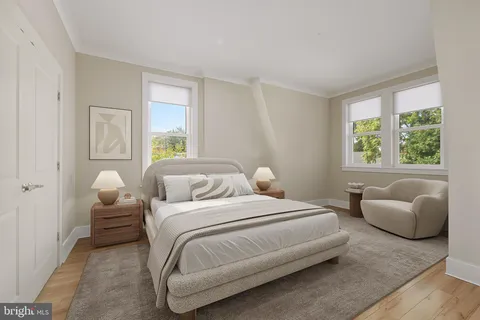 a bedroom with bed couch and window