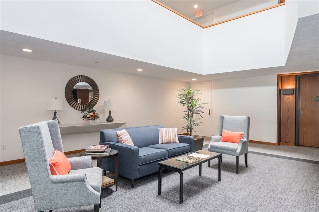 75 Grove Street, Unit 124 Wellesley, MA 02482 - Photo 19 of 22 a living room with furniture and a mirror