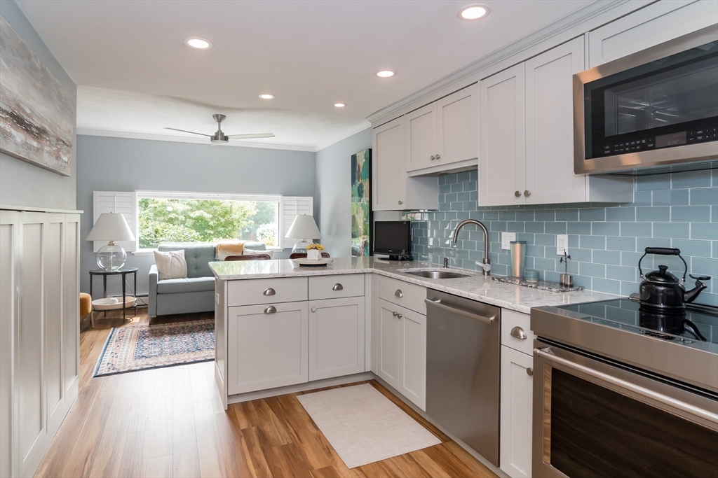 75 Grove Street, Unit 124 Wellesley, MA 02482 - Photo 4 of 22 a kitchen with a sink cabinets stainless steel appliances and a window