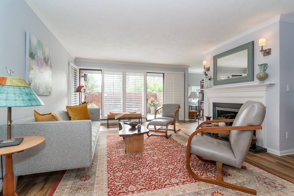 75 Grove Street, Unit 124 Wellesley, MA 02482 - Photo 9 of 22 a living room with furniture a large window and a fireplace