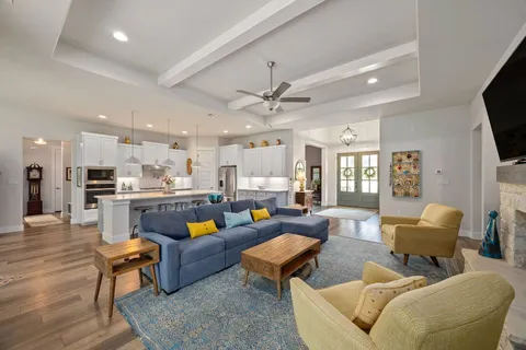 a living room with furniture kitchen view and a flat screen tv