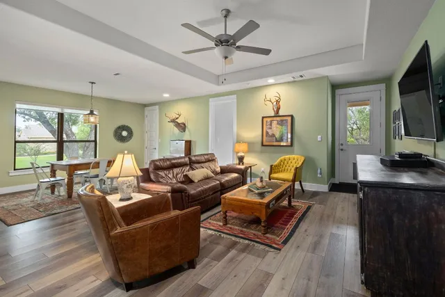 a living room with furniture a flat screen tv and a large window