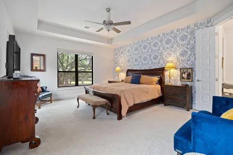 a bedroom with a bed a couch and a chandelier