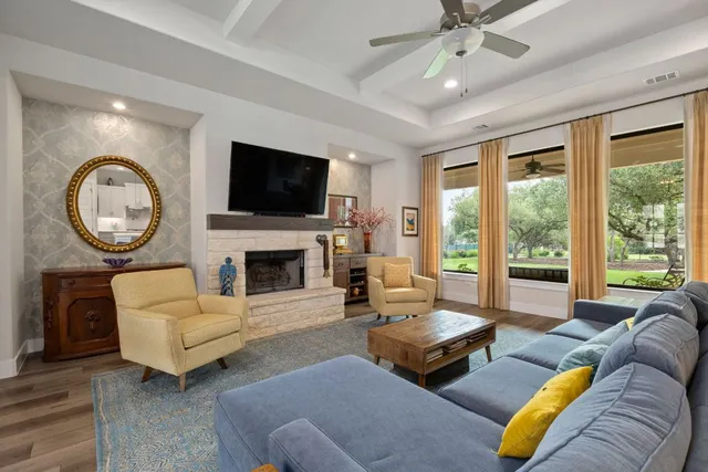 a living room with furniture a large window and a fireplace