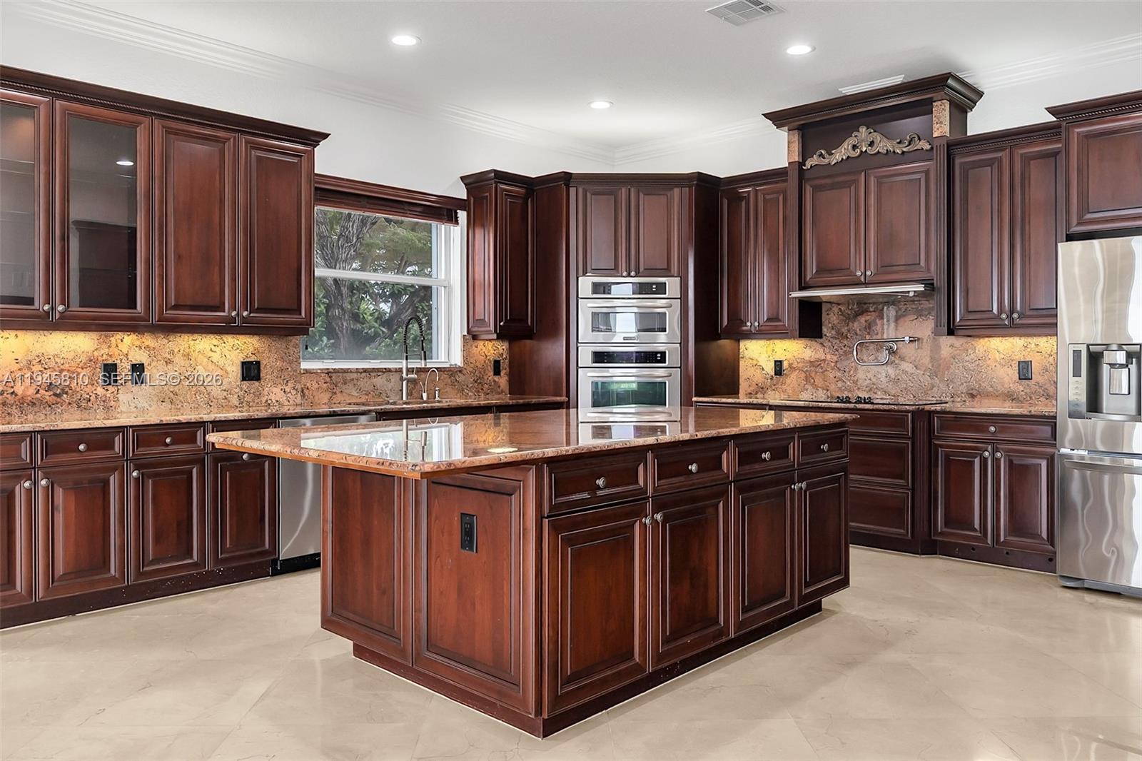 17809 Southwest 54th Street Miramar, FL 33029 - Photo 24 of 94 a kitchen with stainless steel appliances granite countertop wooden cabinets a stove a sink and a oven