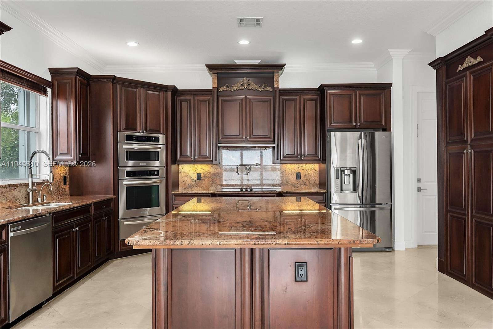 17809 Southwest 54th Street Miramar, FL 33029 - Photo 25 of 94 a kitchen with kitchen island granite countertop stainless steel appliances and refrigerator