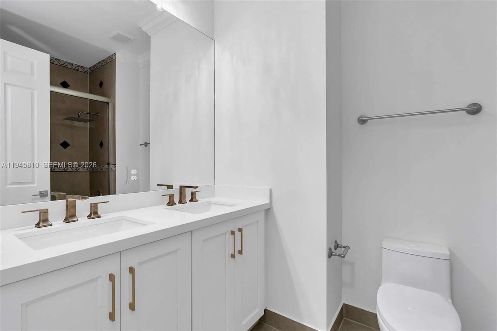 17809 Southwest 54th Street Miramar, FL 33029 - Photo 70 of 94 a bathroom with a sink a toilet a mirror and vanity