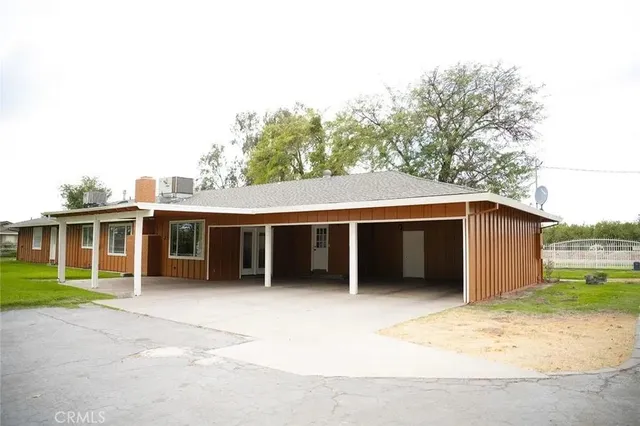 a front view of house with yard and trees in the background