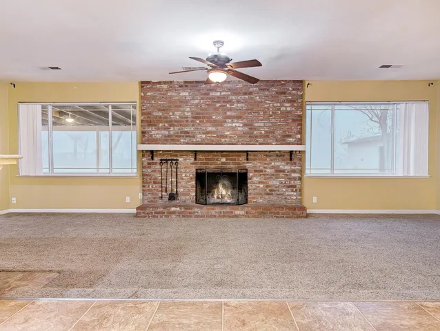 a view of an empty room with a fireplace and a window