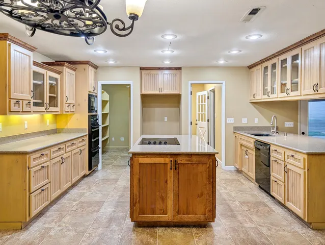 a large kitchen with stainless steel appliances granite countertop a sink and cabinets