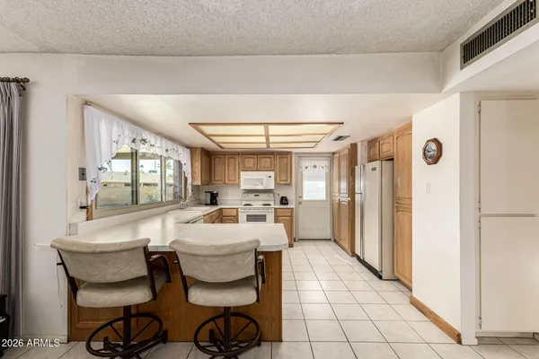 a very nice looking dining room with a large window and kitchen view