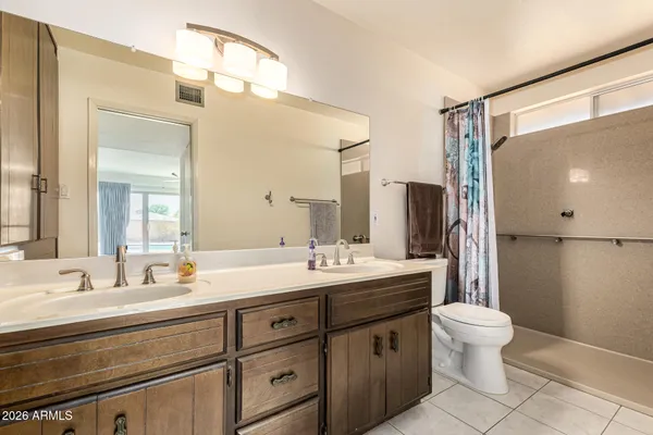 a bathroom with a double vanity sink mirror and toilet