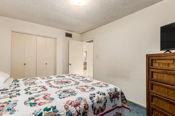 a bedroom with a bed and a flat screen tv