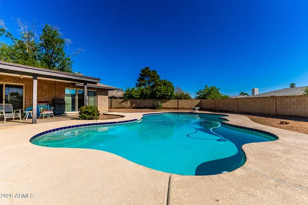 a swimming pool with outdoor seating and yard