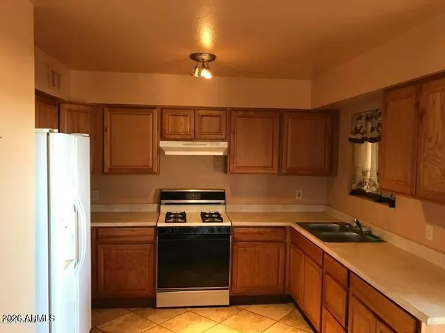 a kitchen with a refrigerator and a sink